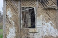 one empty old broken window with a wooden frame on a brown shabby wall Royalty Free Stock Photo