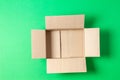 One empty open brown cardboard box on light green background. Top view Royalty Free Stock Photo