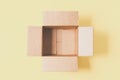 One empty open cardboard box on pastel yellow background. Top view, copy space Royalty Free Stock Photo