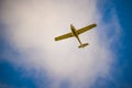 One-engine plane flying under white cloud in blue sky Royalty Free Stock Photo