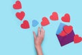 From one envelope go out a lot of red heart with one blue heart that the girl`s hand want to catch. love Valentine day