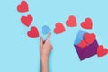 From one envelope go out a lot of red heart with one blue heart that the girl`s hand want to catch. love Valentine day