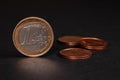 One Euro coin on black background, with many coins blurred in the background Royalty Free Stock Photo