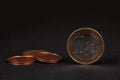 One Euro coin on black background, with many coins blurred in the background Royalty Free Stock Photo