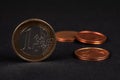 One Euro coin on black background, with many coins blurred in the background Royalty Free Stock Photo