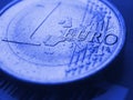 1 one euro coin. In focus inscription with the name of Eurozone currency. Close-up. Dark blue tinted background or wallpaper in Royalty Free Stock Photo