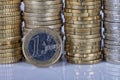 A one euro coin in front of many more coins stacked in columns o Royalty Free Stock Photo
