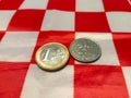 One euro coin placed next to one croatia kuna coin on the white and red squares Royalty Free Stock Photo