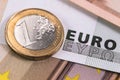 One euro metal coin and euros banknotes