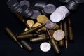 One euro, Russian ruble and small Ukrainian coins with rifle military ammo on black background. Symbolizes war for money Royalty Free Stock Photo