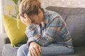 One exhausted and stressed woman at home sitting on the sofa touching his head suffering. Sadness and depression people disease. Royalty Free Stock Photo