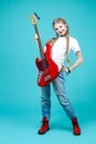 One Expressive Caucasian Teenager Guitar Player With Red Shiny Bass Guitar Posing In Casual White Shirt Showing Pleased Expression