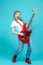 One Expressive Caucasian Teenager Guitar Player With Red Shiny Bass Guitar Posing In Casual White Shirt Showing Pleased Expression