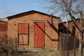 Old brown brown barn with a red door in the yard Royalty Free Stock Photo