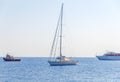 One fancy boat docked at sea and three boat passing by with clean sky