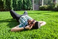 One fashion middle eastern man with beard, fashion hair style is resting on beautiful green grass day time. Royalty Free Stock Photo