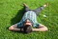 One fashion middle eastern man with beard, fashion hair style is resting on beautiful green grass day time. Royalty Free Stock Photo