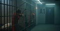 One female prisoner stands behind metal bars, another sits on the bed