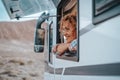 One female tourist enjoy view and freedom feeling inside a camper van vehicle looking outside the window. Concept of nomadic life Royalty Free Stock Photo