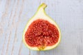 One fig sliced in half on top of a garden table. Royalty Free Stock Photo