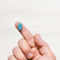 One Finger Holding A Blue Pill On White Wooden Background Royalty Free Stock Photo