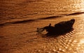 One fisherman going on a fishing boat in orange sunset in the river in Ben Tre, Vietnam Royalty Free Stock Photo