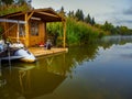 One Fisherman house and inflatable boat on river hiding in a reeds Royalty Free Stock Photo