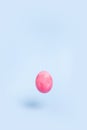 One flying pink chiken egg on a blue background Royalty Free Stock Photo