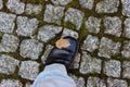 One foot in formal shoes on historical cobblestones.