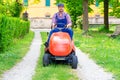 One gardener driving riding lawn mower garden Royalty Free Stock Photo