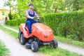 One gardener driving riding lawn mower garden Royalty Free Stock Photo