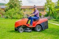 One gardener driving riding lawn mower garden Royalty Free Stock Photo