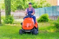 One gardener driving riding lawn mower garden Royalty Free Stock Photo