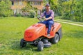 One gardener driving riding lawn mower garden Royalty Free Stock Photo