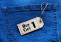 But one get one tag on blue jean background. Royalty Free Stock Photo