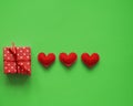 One gift in a box and valentines on a green background. Colors are green, red, black, kraft and white. Royalty Free Stock Photo