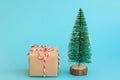 One gift box wrapped in craft paper tied with red white ribbon Christmas trees on blue background. New Year corporate presents Royalty Free Stock Photo