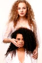 One girl closes the other`s eyes. Afro and Blond Royalty Free Stock Photo