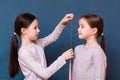 One girl measures another growth with a measuring tape on a blue background Royalty Free Stock Photo