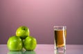 One glass of apple juice with green apples in the beautiful pink background. Reflected surface. Summer day. Good mood. Royalty Free Stock Photo