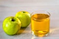 One glass of apple juice with green apples in the sunset background. Nice white wood table. Summer day. Good mood. Royalty Free Stock Photo