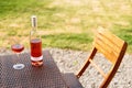 One glass and bottle of red or rose wine in autumn vineyard on wooden wicker table. Harvest time, picnic, fest theme. Royalty Free Stock Photo