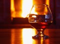 One glass of cognac on background of old brick fireplace Royalty Free Stock Photo