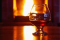 One glass of cognac on background of old brick fireplace Royalty Free Stock Photo