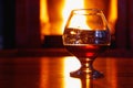 One glass of cognac on background of old brick fireplace Royalty Free Stock Photo