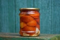 One glass jar with red canned tomatoes stands on a wooden table Royalty Free Stock Photo