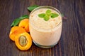 Milkshake apricot in glassful on board Royalty Free Stock Photo