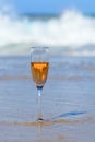 One glass of rose champagne or cava sparkling wine served on white sandy beach and blue ocean water, romantic vacation, winter sun Royalty Free Stock Photo