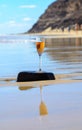 One glass of rose champagne or cava sparkling wine served on white sandy tropical beach and blue ocean water, romantic vacation, Royalty Free Stock Photo