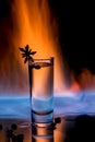 One glass of sambuca on fire with burning sambuca, coffee grains and anise star on a black background Royalty Free Stock Photo